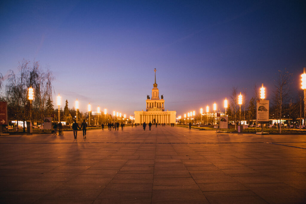 O Pavilhão Central, com a Casa dos Povos da Rússia no final de um um extenso caminho iluminado do VDNKh à noite.