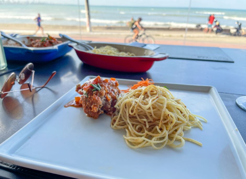Almoço no Gulliver Mar Restaurante, com um prato de macarrão e carne, em uma mesa com vista para o mar que banha a Praia de Cabo Branco.