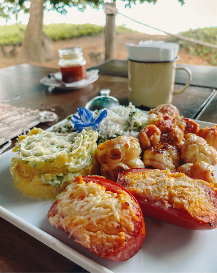 Legumes recheados, arroz e lagosta servidos em um prato quadrado e branco no Restaurante Caiuia.